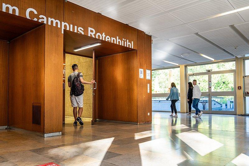 Eingang mit Holzverkleidung und Schrift „Campus Rotenbühl“.