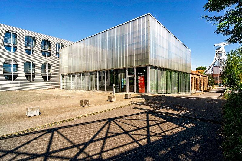 Modernes Gebäude mit Glasfassade und Eingang mit „htw saar“-Schriftzug.