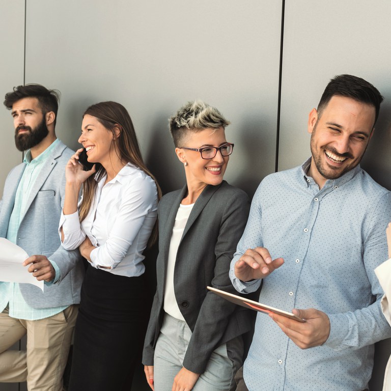 Vier Personen stehen nebeneinander, lachend und im Gespräch